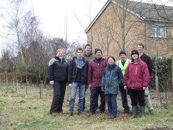 Volunteers standing proud by planted row of cherry trees